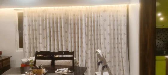 Cream curtain with gold motif under cove lighting